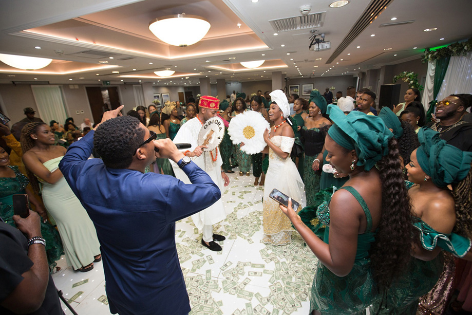 Bride and groom dance on money-covered dancefloor with their guests